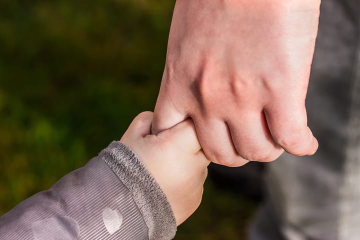 adult and child holding hands